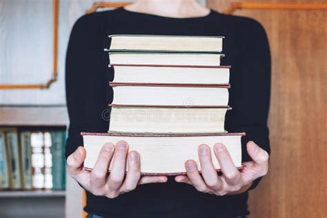 Man Student Holding Many Books In Hands On The Background Of