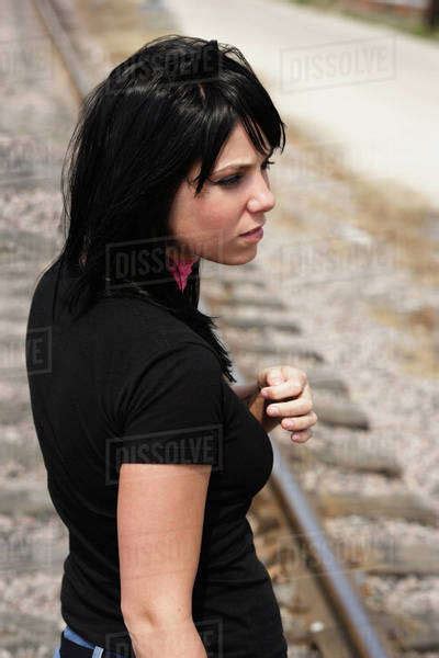 Woman Standing On Railroad Tracks Stock Photo Dissolve