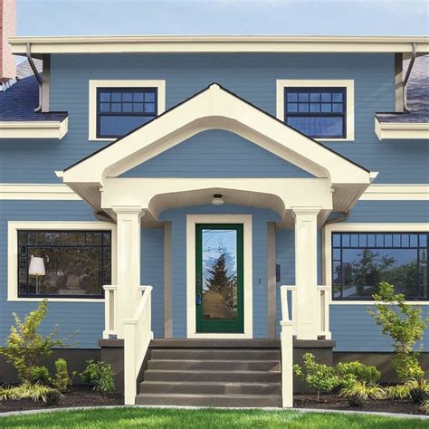 A Blue House With White Trim And Green Door