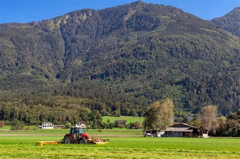 Premium Photo Tractor In A Field On A Farm Cutting Grass For Cattle Feeding