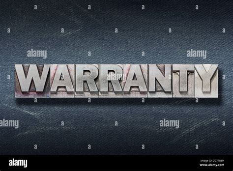 Warranty Word Made From Metallic Letterpress On Dark Jeans Background