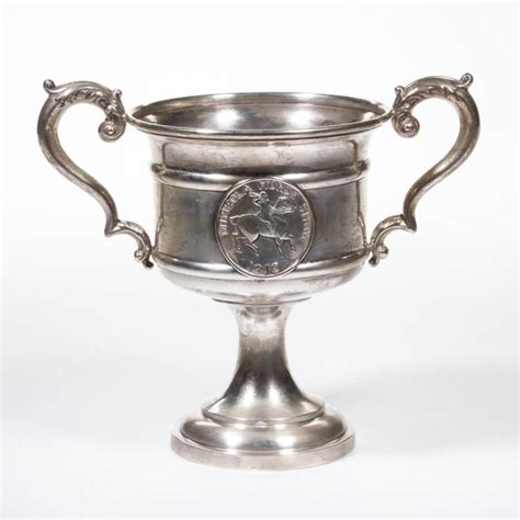 an antique silver cup with two handles and a coin in the middle on a ...