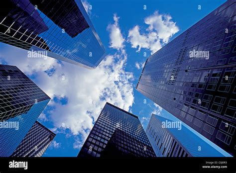 Looking Up Between Modern Skyscrapers In Lower Manhattan With Blue Sky