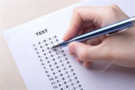 Close Up Of Hand Filling Test Score Sheet With Answers Stock Photo