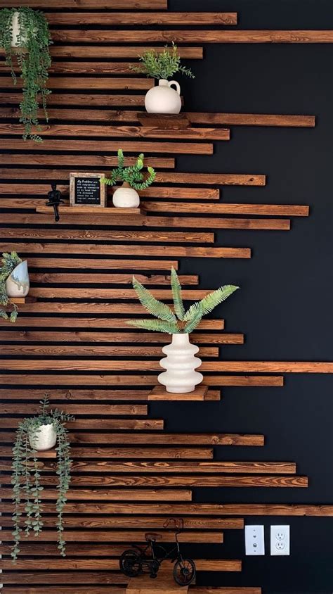 Some Plants Are Sitting In White Vases On Wooden Slatted Wall Behind Them