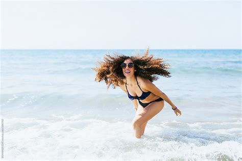 Portrait Of A Woman Enjoying A Sunny Day On The Beach By Stocksy