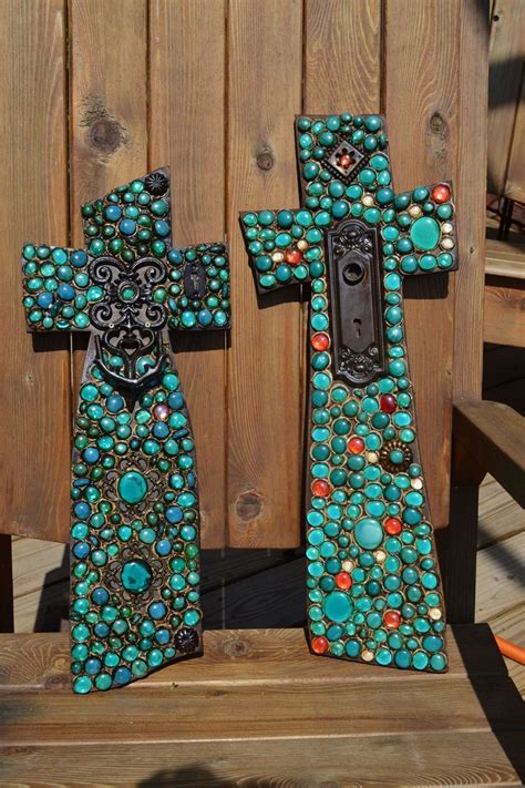 Two Decorative Crosses Sitting On Top Of A Wooden Bench