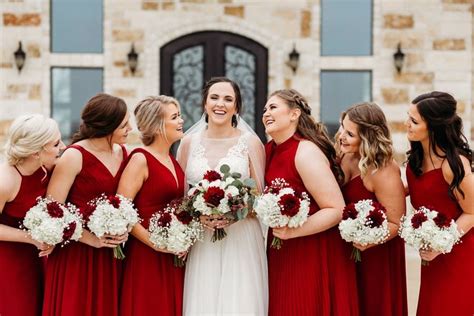 Bride With Bridal Party Wearing Deep Red Gowns And Holding White And