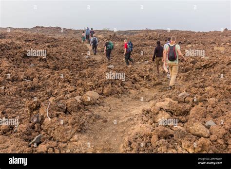 AFAR, ETHIOPIA - MARCH 26, 2019: Tourists walking across lava fields at ...