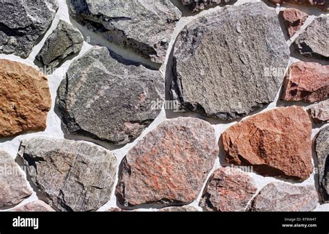 Stones of different sizes, shapes and colors on an exterior rock wall Stock Photo - Alamy