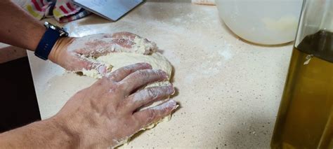 A Person Kneading Dough On Top Of A Counter