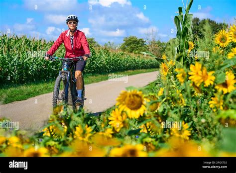 Nice Senior Woman Cycling With Her Electric Mountain Bike In A Blooming