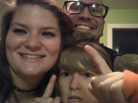 A Man And Woman Posing For The Camera With Their Fingers Up In Front Of Them