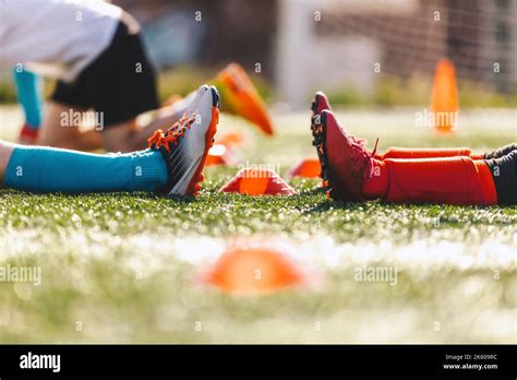 Kids In Two Sports Teams Legs Of Two Soccer Players Sit On Soccer