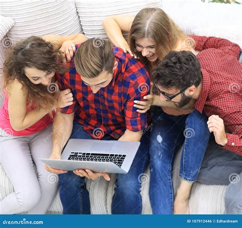 Group Of Friends Looking At The Photo On The Laptop Stock Photo