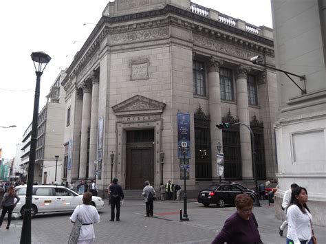 People Are Walking In Front Of An Old Building On A Street Corner With