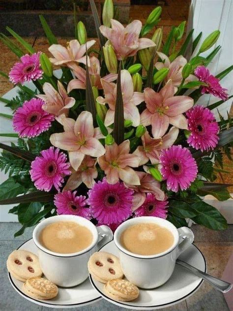 Two Cups Of Coffee And Some Cookies On A Saucer With Flowers In The