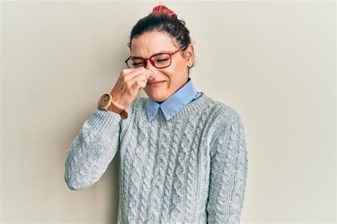 Young Caucasian Woman Wearing Casual Clothes And Glasses Smelling