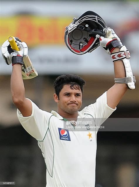 Pakistan cricketer Azhar Ali raises his bat and helmet in celebration... News Photo - Getty Images