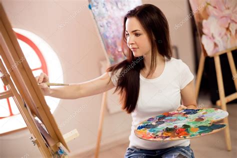 Female Artist Working On Painting In Studio — Stock Photo © bezzznika #114461456