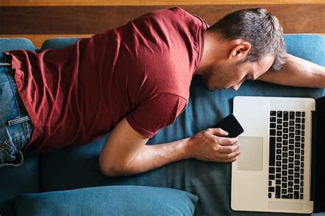 Premium Photo | Tired guy sleeping on sofa with devices at home