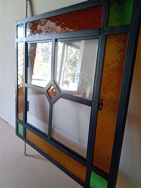 An Old Stained Glass Window Is Hanging On The Wall