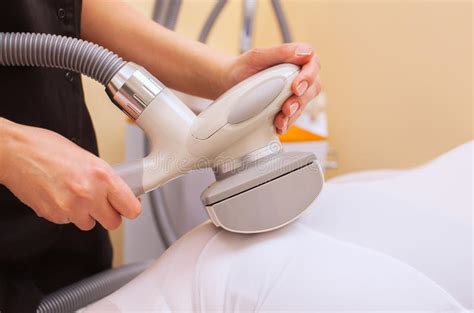 The Masseur Makes An Hardware Massage On The Patient`s Legs In A White