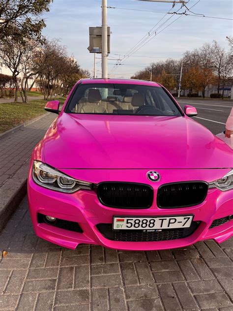 A Pink Bmw Car Parked On The Side Of The Road