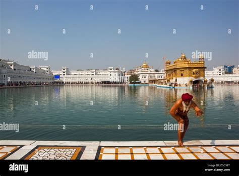 A Sikh Devotee Stepping Out Of The Holy Pool Inside The Golden Temple