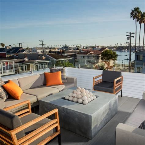 An Outdoor Living Area With Couches Chairs And Tables On Top Of A Roof