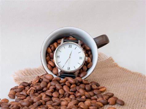 Premium Photo A Wrist Watch In A Coffee Cup Covered With Grains Of