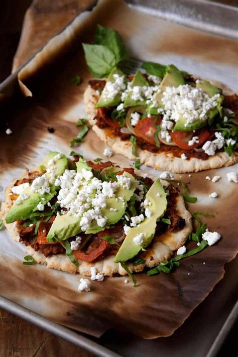 Huaraches Topped With Chorizo Refried Beans Tomatoes And Avocados