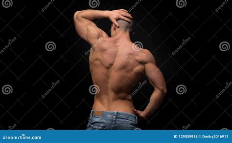 The Back View Of Torso Of Attractive Male Body Builder On Dark