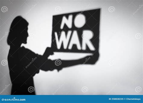 Shadow Of Woman Holding Poster With Words No War On Light Background