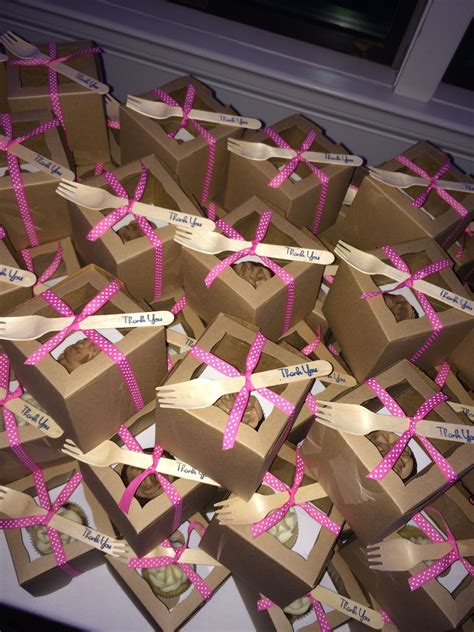 There Are Many Boxes With Pink Ribbons Tied Around The Forks And Spoons