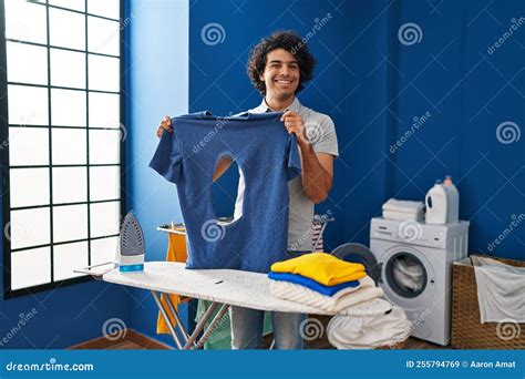 Hispanic Man With Curly Hair Ironing Holding Burned Iron Shirt At