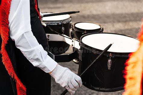 Person Holding Drumsticks Playing In A Marching Band Stock Photo