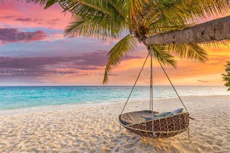 Tropical sunset beach and sky background as exotic summer landscape with beach swing or hammock ...