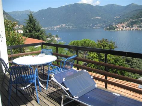 There Is A Table And Chairs On The Balcony Overlooking The Water With