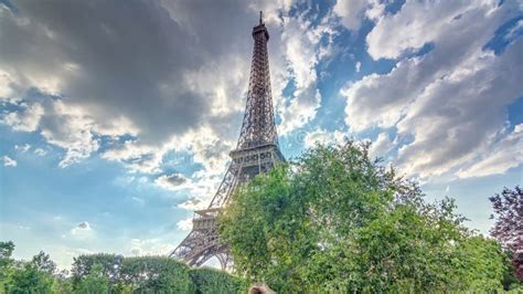 The Eiffel Tower With Warm Rays Of Light In Clouds During Sunset