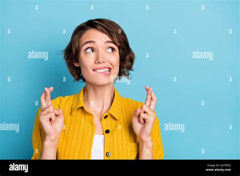 Photo Of Nervous Hopeful Lady Bite Lip Crossed Fingers Look Empty Space Wear Yellow Shirt