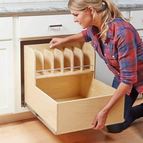 a woman is opening the drawers in her kitchen