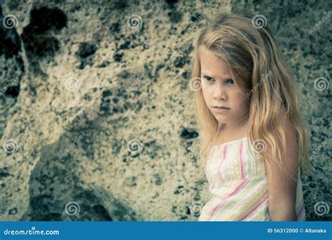 Portrait De La Petite Fille Blonde Triste Sasseyant Sur La Plage Photo