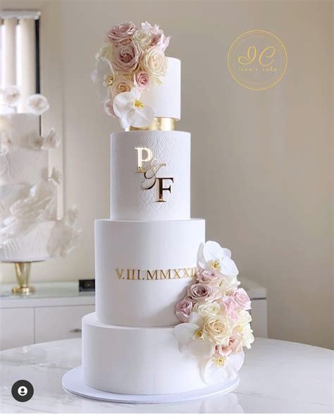 A Three Tiered Wedding Cake With Flowers On Top And The Words Pf