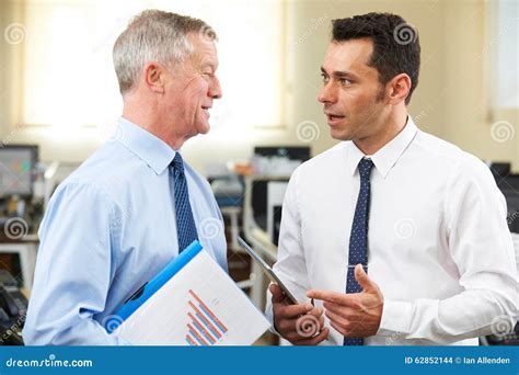 Businessman Having Discussion With Senior Mentor In Office Stock Photo