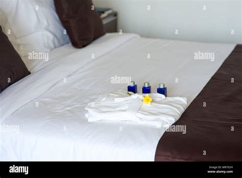 bathroom amenities with bathrobe on bed in hotel room Stock Photo - Alamy