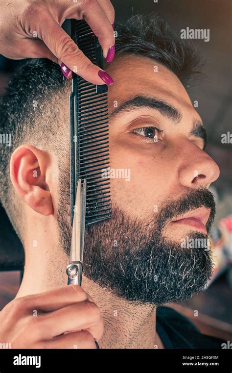 Female Barber Beard Cut A Clients Beard With Clippers In A Barber Shop