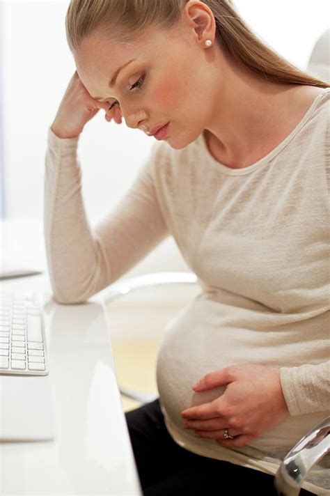 Pregnant Woman At Desk With Head In Hands Photograph By Ian Hooton