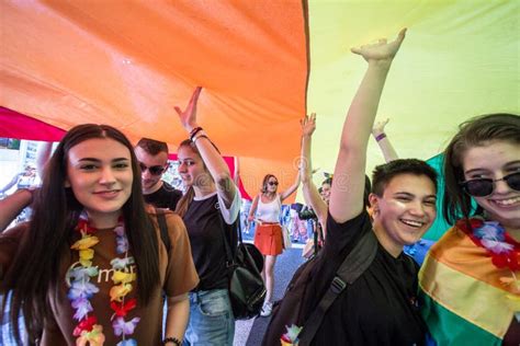 Muchedumbre De Protestors Que Se Colocan Debajo De Una Bandera Gay Del