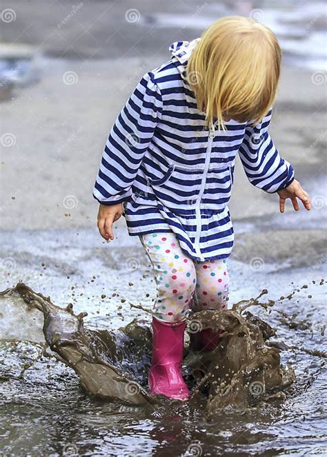 Playful Child Outdoor Jump Into Puddle In Boot Stock Photo Image Of